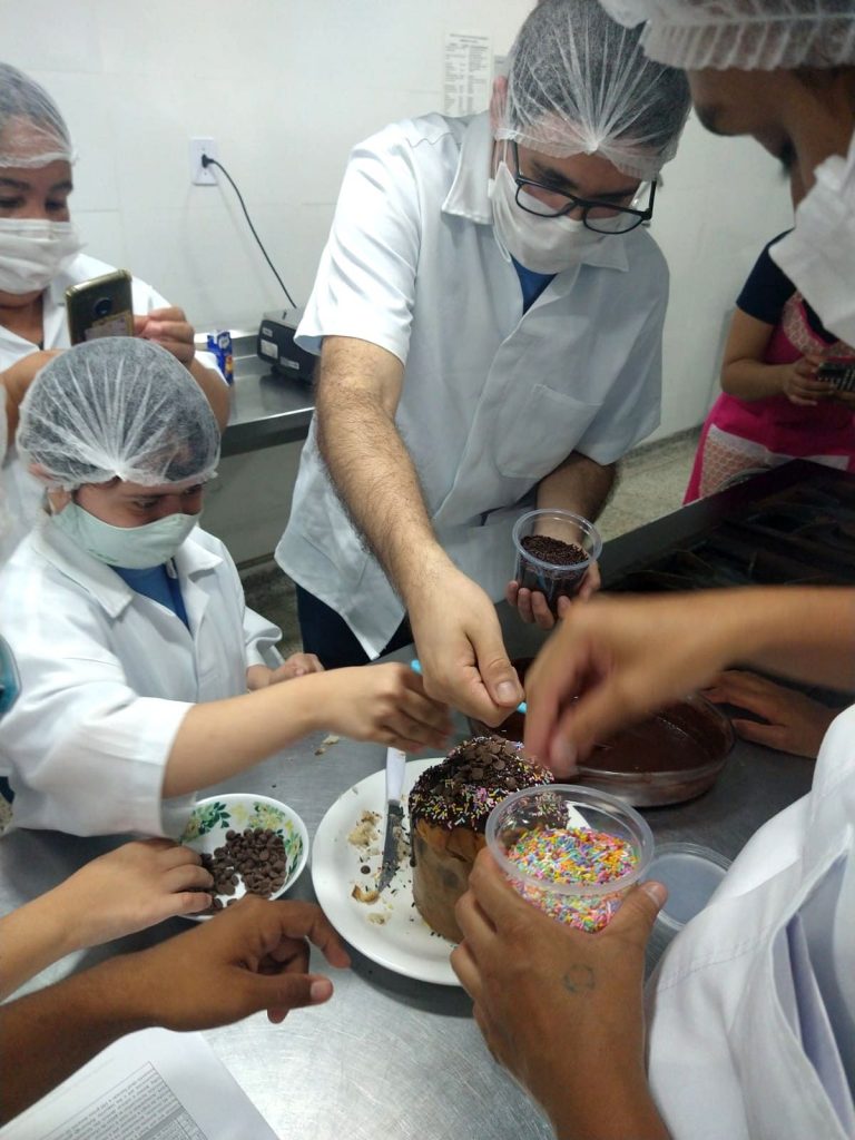 Atendidos da APAE DF, confeitando um panetone.